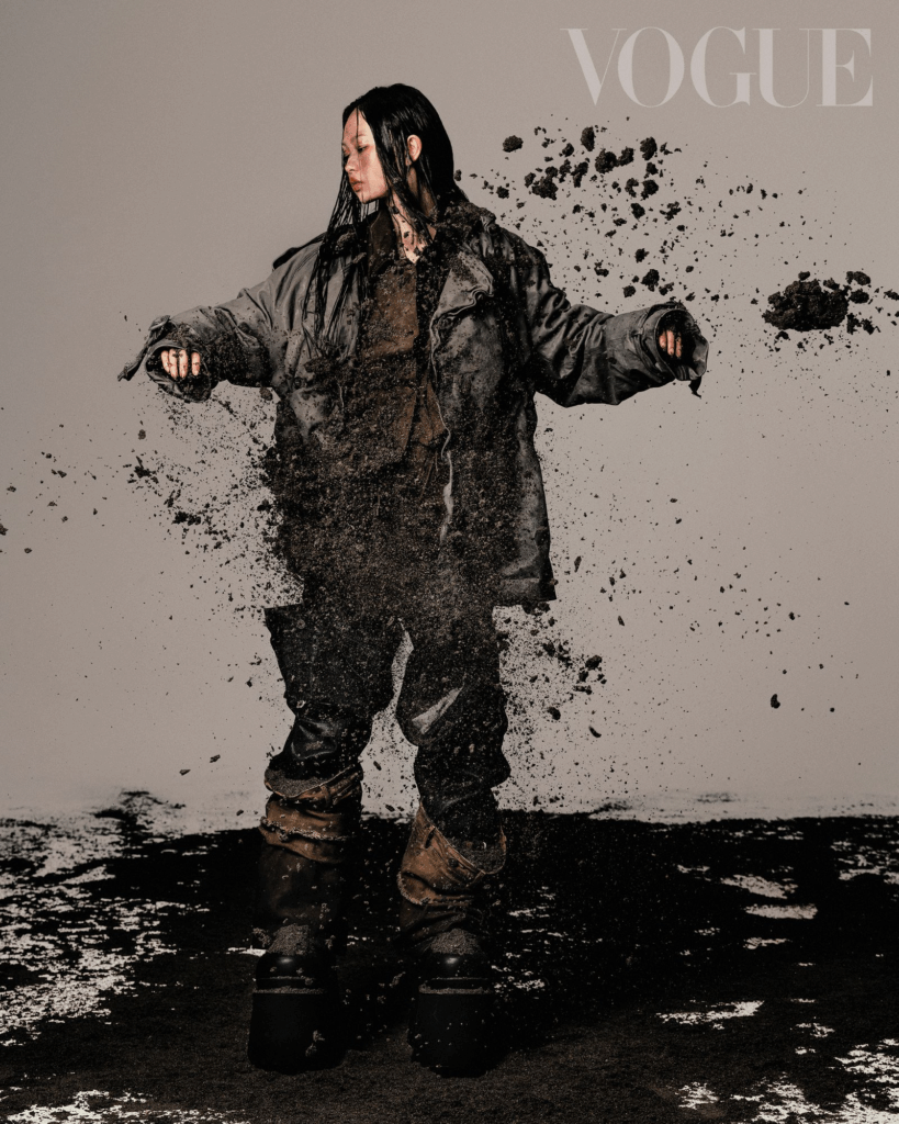 Zoe Fang is wearing a grey wrinkled jacket, ACNE STUDIOS a dark brown lapel jacket, PRADA black trousers, black thick-soled mid-length boots, BALENCIAGA a rendered distressed top, dark blue denim sleeves, brown denim sleeves all by MARRKNULL